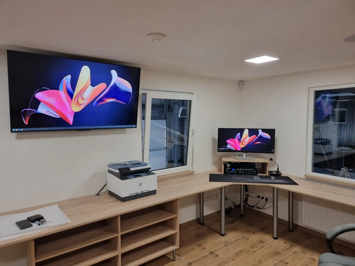 Kancelář s monitorem, televizí a tiskárnou na konci datové trasy