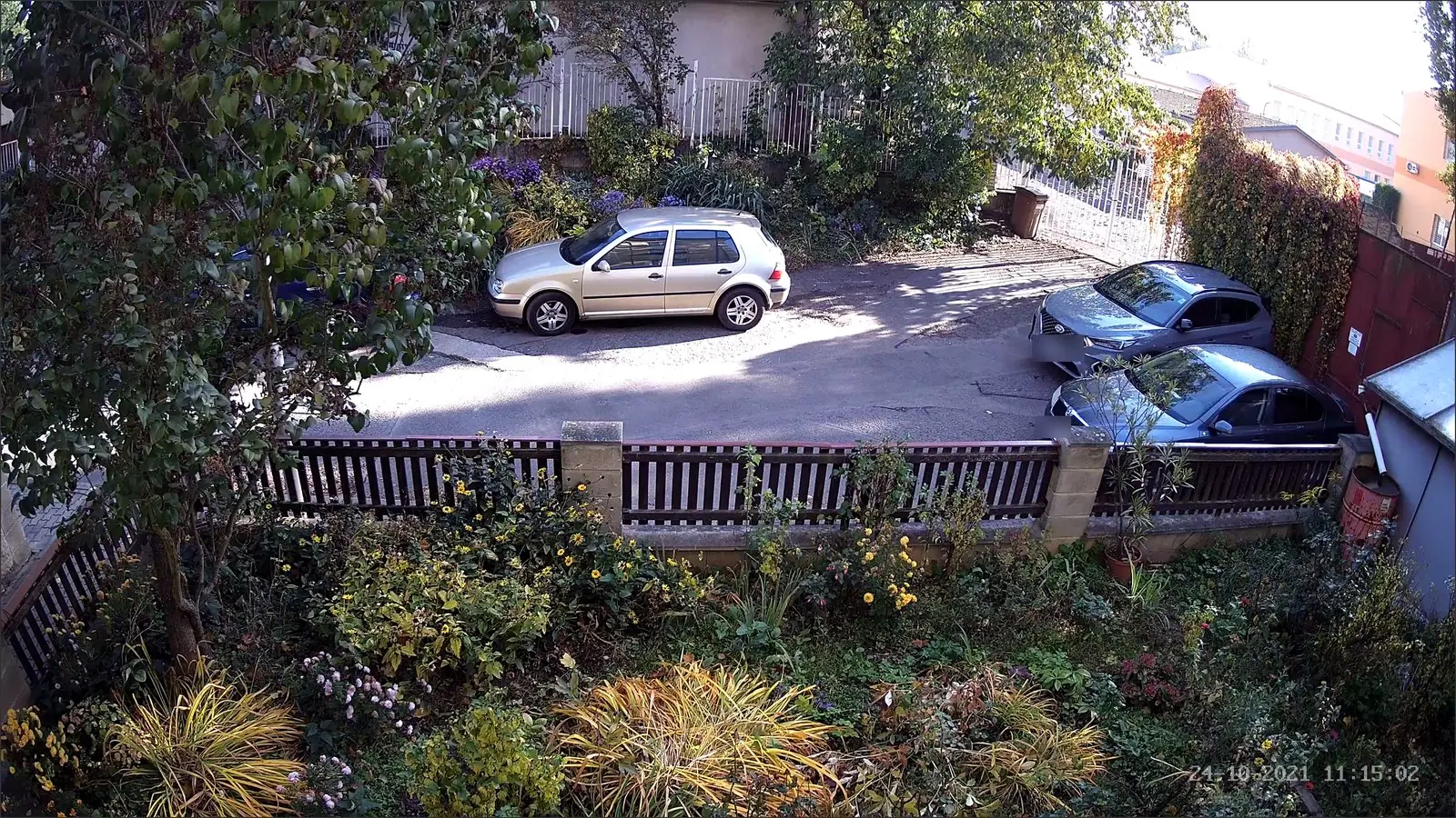Denní snímek z kamery na dvůr s parkujícími auty